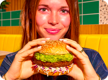 Woman enjoying a burger with fresh avocado